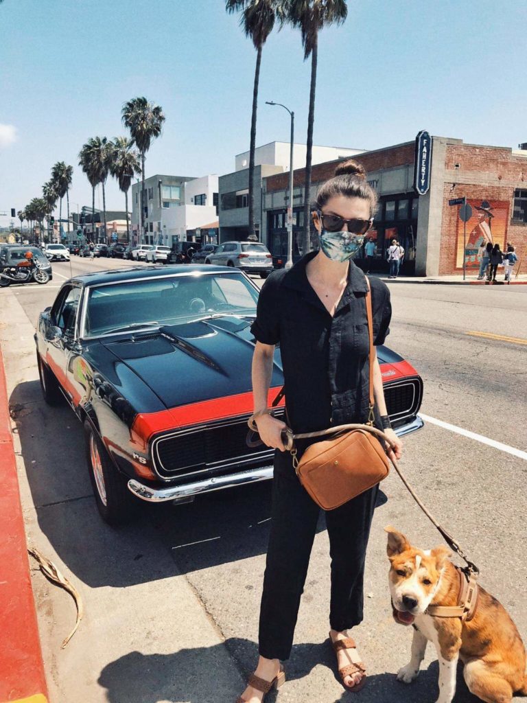 Vanessa and dog in front of a muscle car in LA